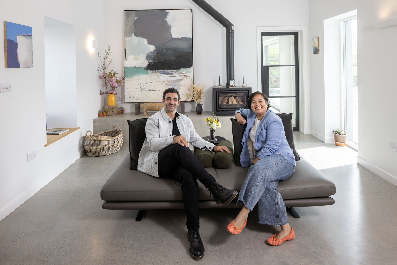 Richard and Boo in their snug. The floors are polished concrete throughout the living areas. The sofa is from Ligne Roset. Photo: Tony Gavin