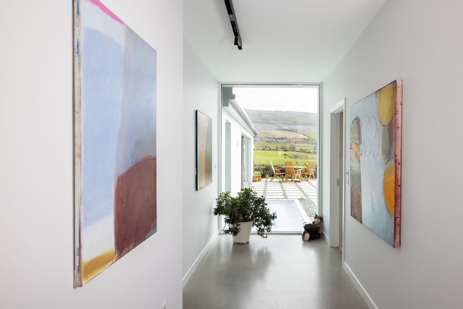 Wall spaces are used to display Richard&rsquo;s paintings while the many windows allow for fantastic glimpses of the landscape. There is a plunge pool just outside this window. Photo: Tony Gavin